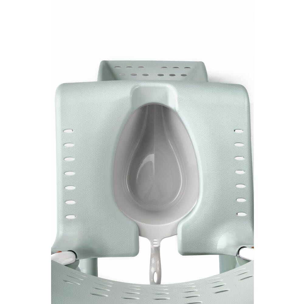 Etac Clean Commode Pan positioned in a home environment such as a bedroom or bathroom, demonstrating its discreet appearance.