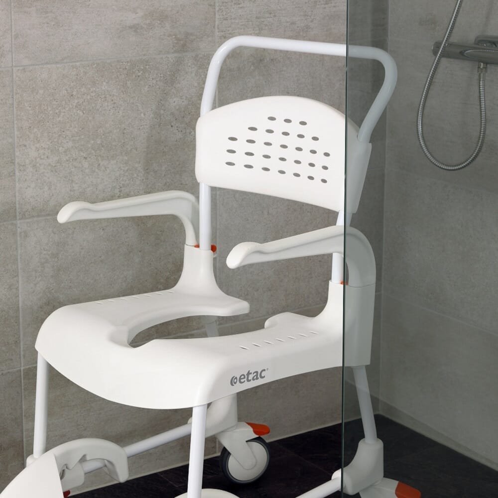 Etac Clean Shower Commode Chair with lid closed, highlighting the padded seat and discreet design.
