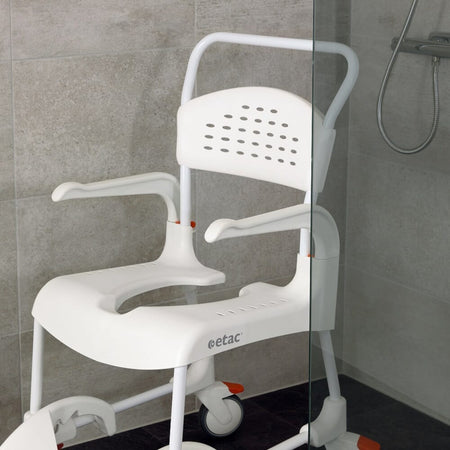 Etac Clean Shower Commode Chair with lid closed, highlighting the padded seat and discreet design.