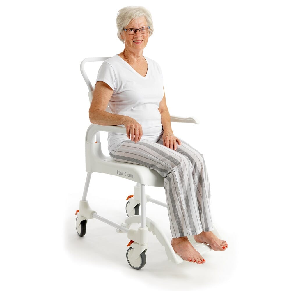 Etac Clean Shower Commode Chair in use in a home setting, with lid open to illustrate accessibility and convenience.