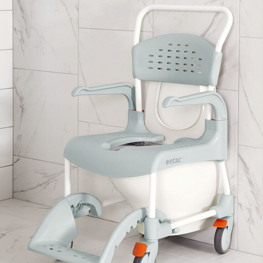 Etac Clean Shower Commode Duo Pack with lid closed, highlighting the padded seat and discreet design.