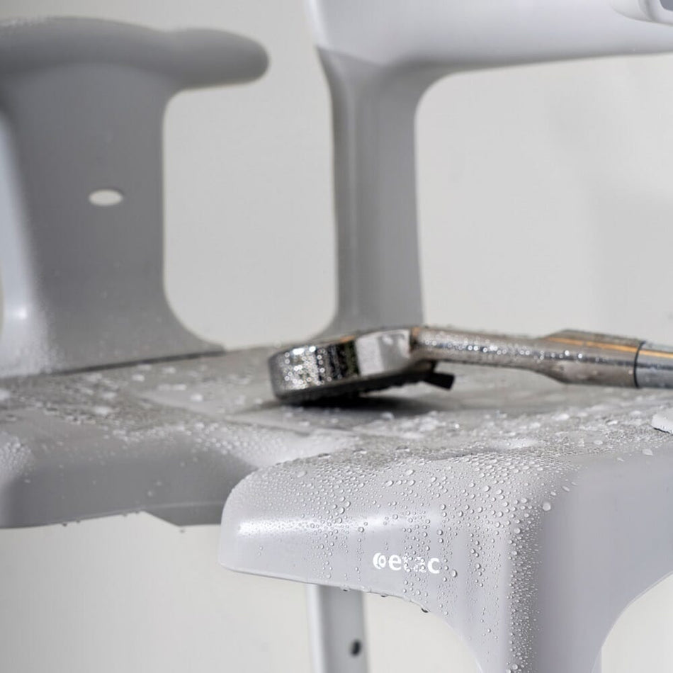 Front view of Etac Swift Shower Chair showing drainage holes in the seat and the supportive backrest design.