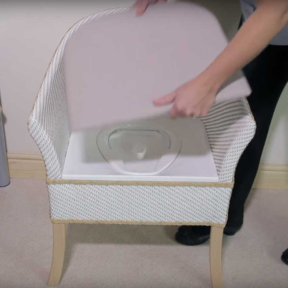 Gordon Ellis Basketweave Commode Chair with lid closed, highlighting the padded seat and discreet design.