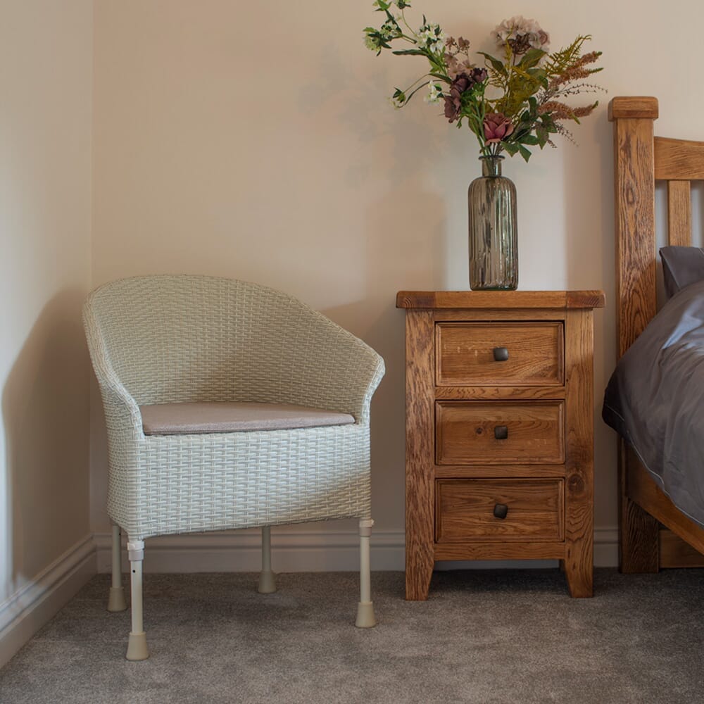 Demonstration of removing the commode pan or adjusting the height on Gordon Ellis Walton Height Adjustable Commode.