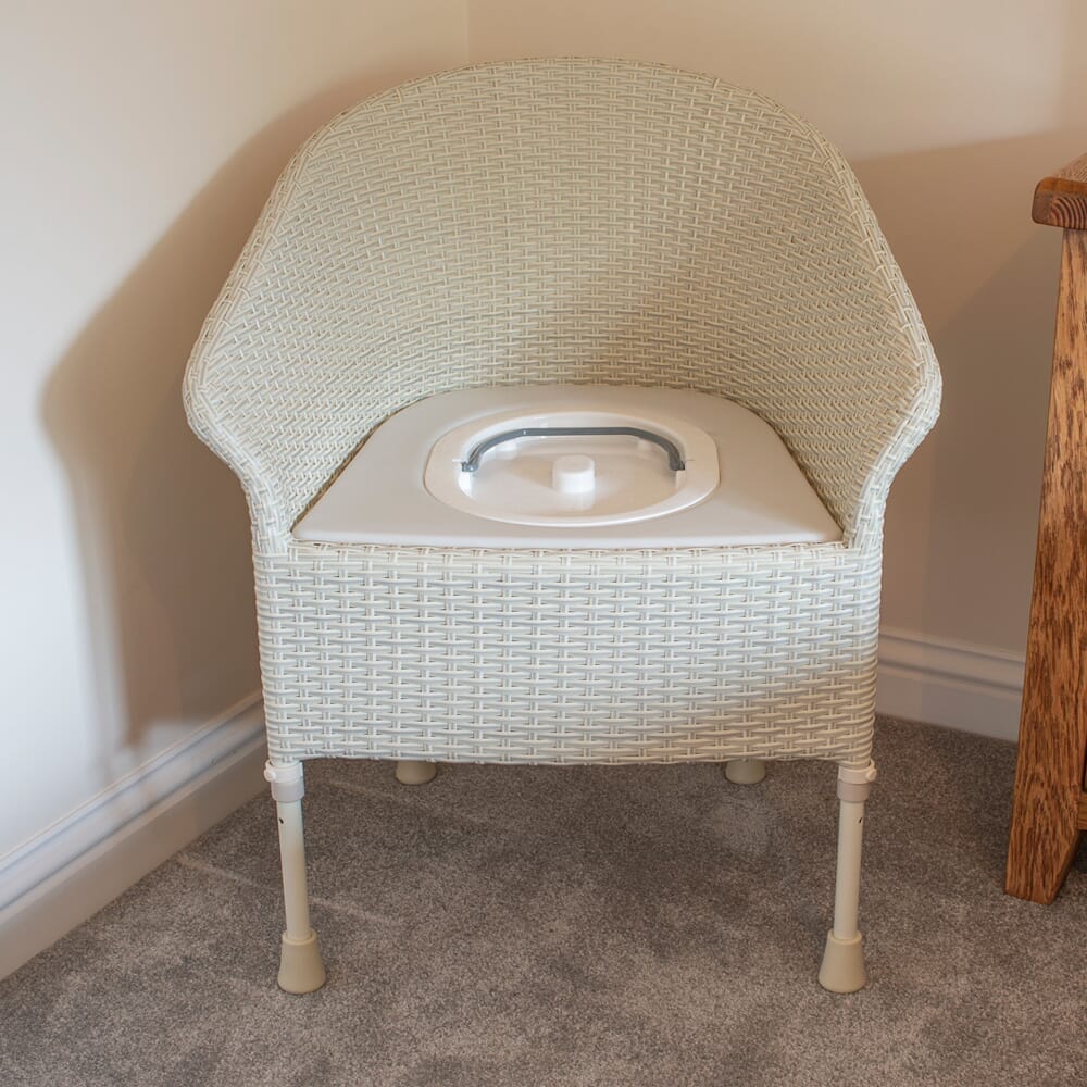 Gordon Ellis Walton Height Adjustable Commode in use in a home setting, with lid open to illustrate accessibility and convenience.