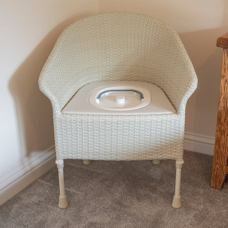 Gordon Ellis Walton Height Adjustable Commode in use in a home setting, with lid open to illustrate accessibility and convenience.