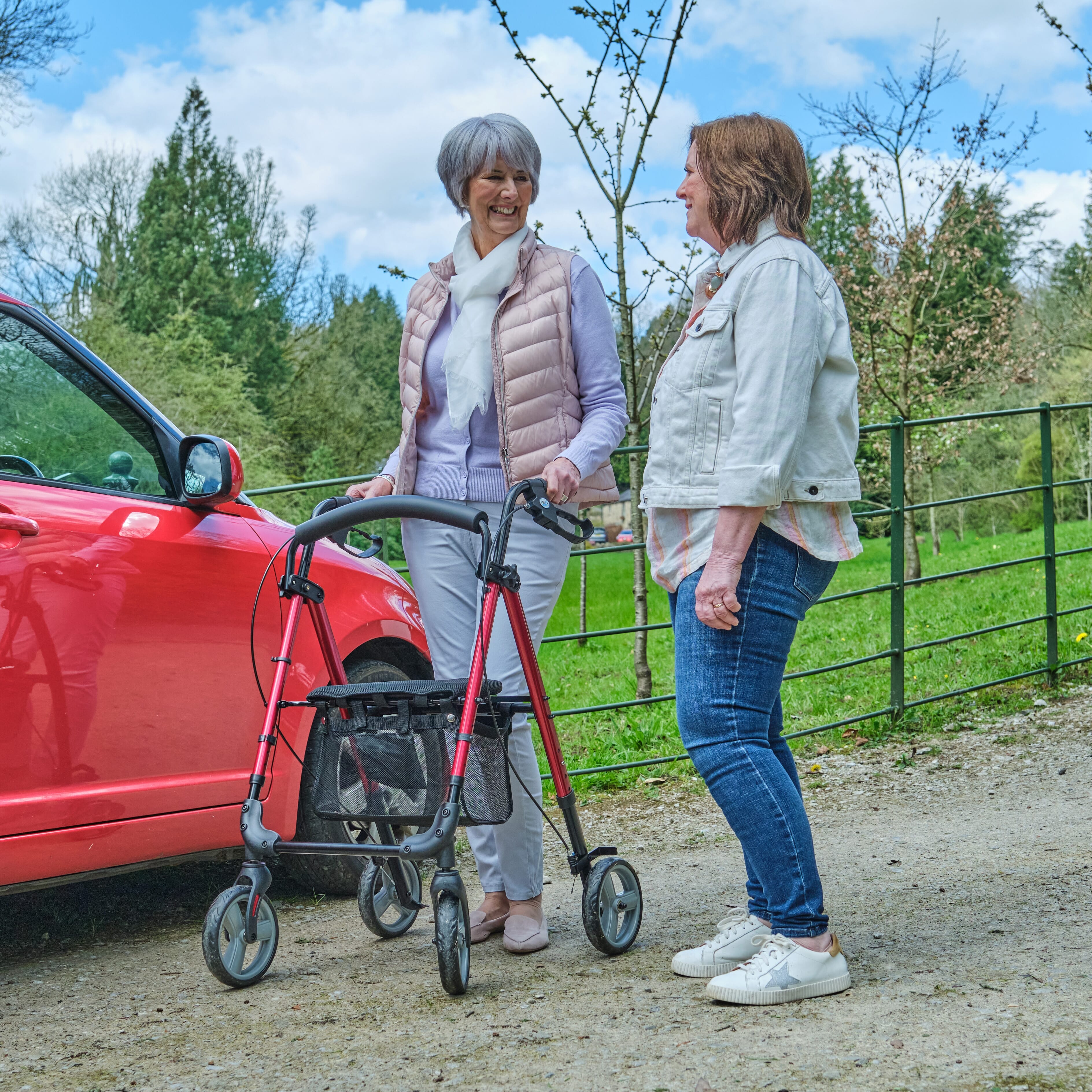 Front view of NRS 4 Wheel Lightweight Rollator rollator with seat and padded backrest, showing the handlebars and brake cables.