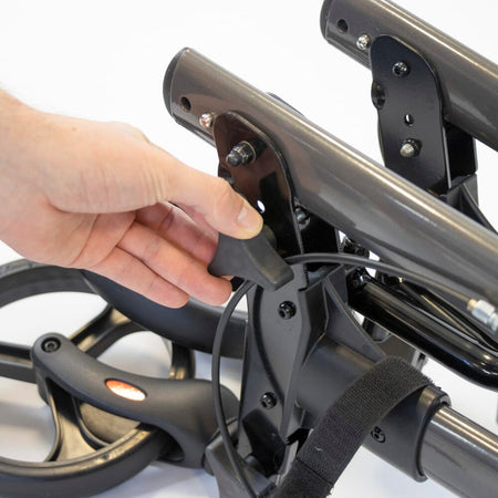 Close-up of a folding release lever on NRS 4 Wheel Triple Fold Aluminium Rollator rollator being operated by hand.