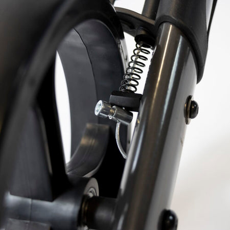 Close-up of the brake mechanism on NRS 4 Wheel Triple Fold Aluminium Rollator rollator's wheel with spring and cable detail.
