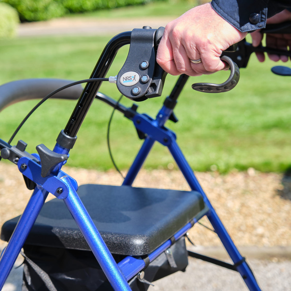 Close-up of a folding release lever on NRS A-Series Lightweight 4 Wheel Rollator rollator being operated by hand.