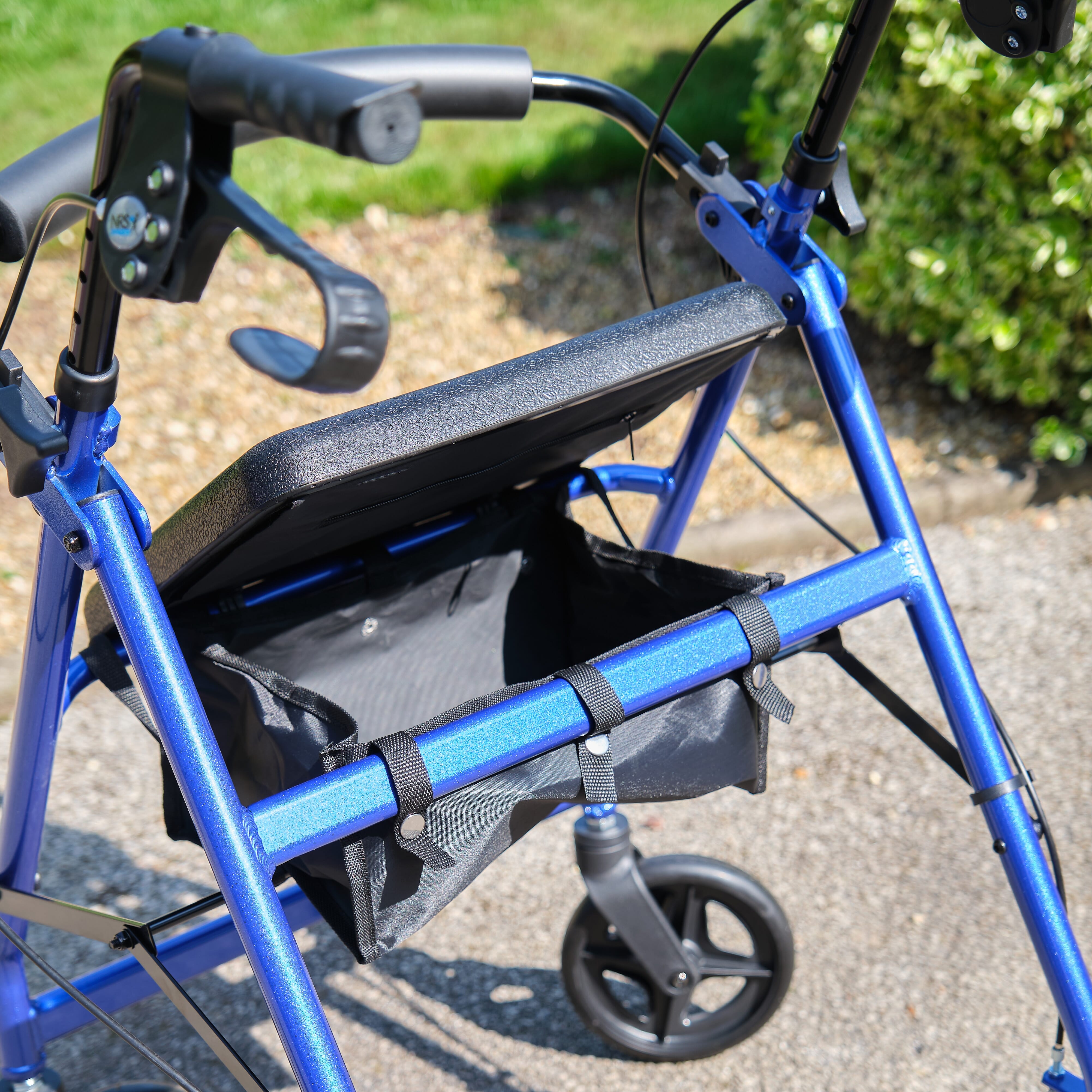 Close-up of the brake mechanism on NRS A-Series Lightweight 4 Wheel Rollator rollator's wheel with spring and cable detail.