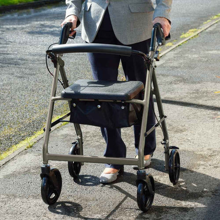 Fully folded NRS A-Series Lightweight 4 Wheel Rollator rollator lying flat, showing the triple-fold mechanism and compact size.