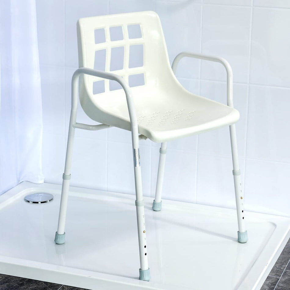 Angled view of NRS Adjustable Economy Value Shower Chair with moulded seat, supportive backrest and height-adjustable legs on a plain background.