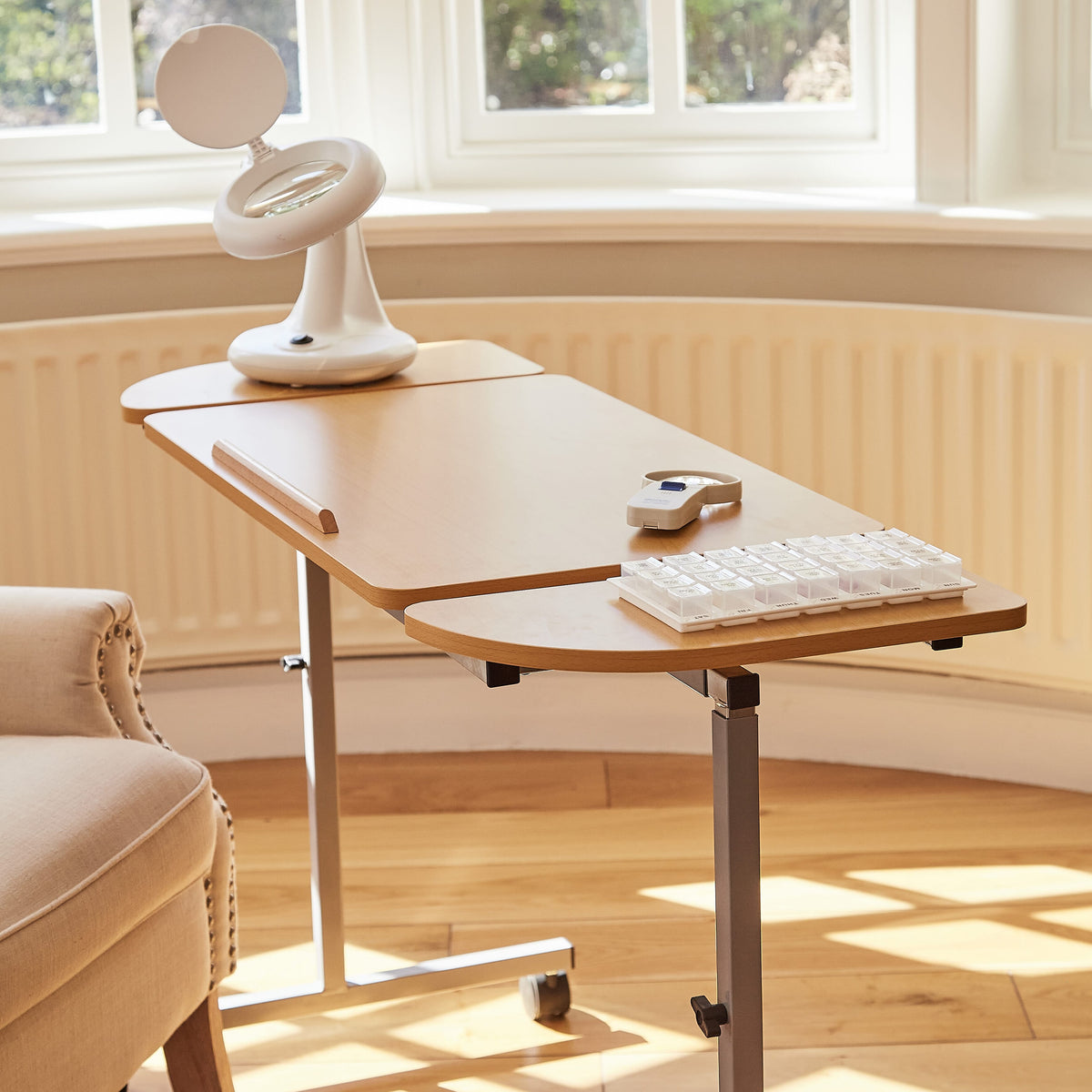 Side view of NRS Adjustable Overbed Table showing the tilting top and height-adjustable chrome stems.