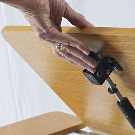 Close-up of the castor wheels on NRS Adjustable Overbed Table, showing the smooth-rolling casters and brake mechanism.