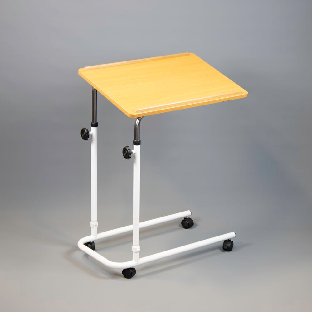 Angled view of NRS Beech Overbed Overchair Table with beech-effect tilting table top and white U-shaped base on castors against a neutral background.