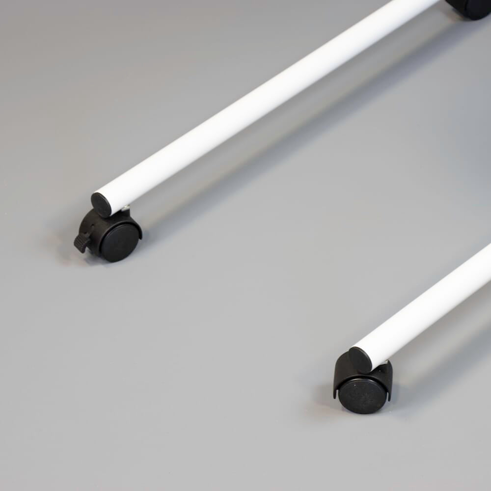 Close-up of the castor wheels on NRS Beech Overbed Overchair Table, showing the smooth-rolling casters and brake mechanism.