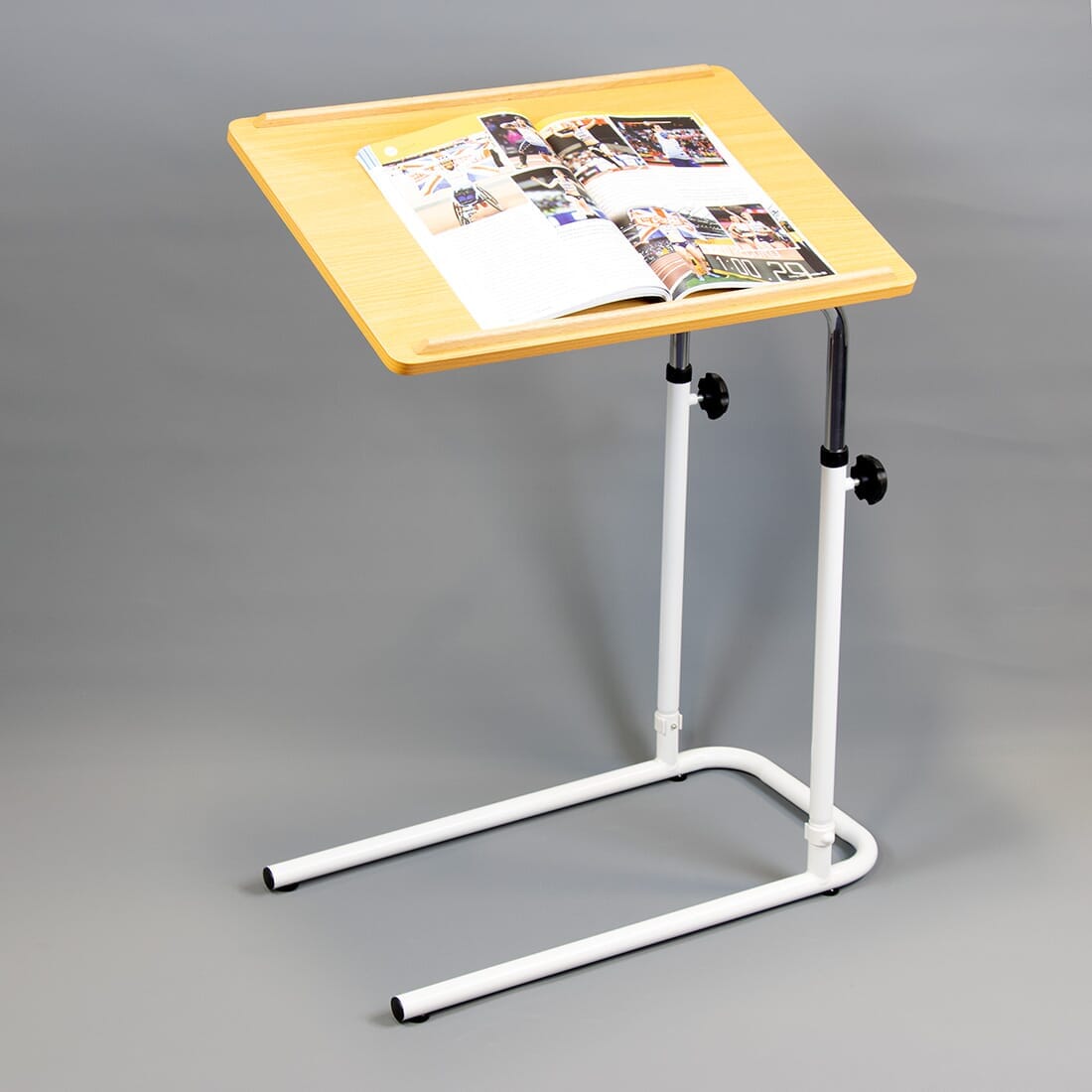 NRS Beech Overbed Overchair Table in use with a magazine or book on the table top, demonstrating its generous surface area.