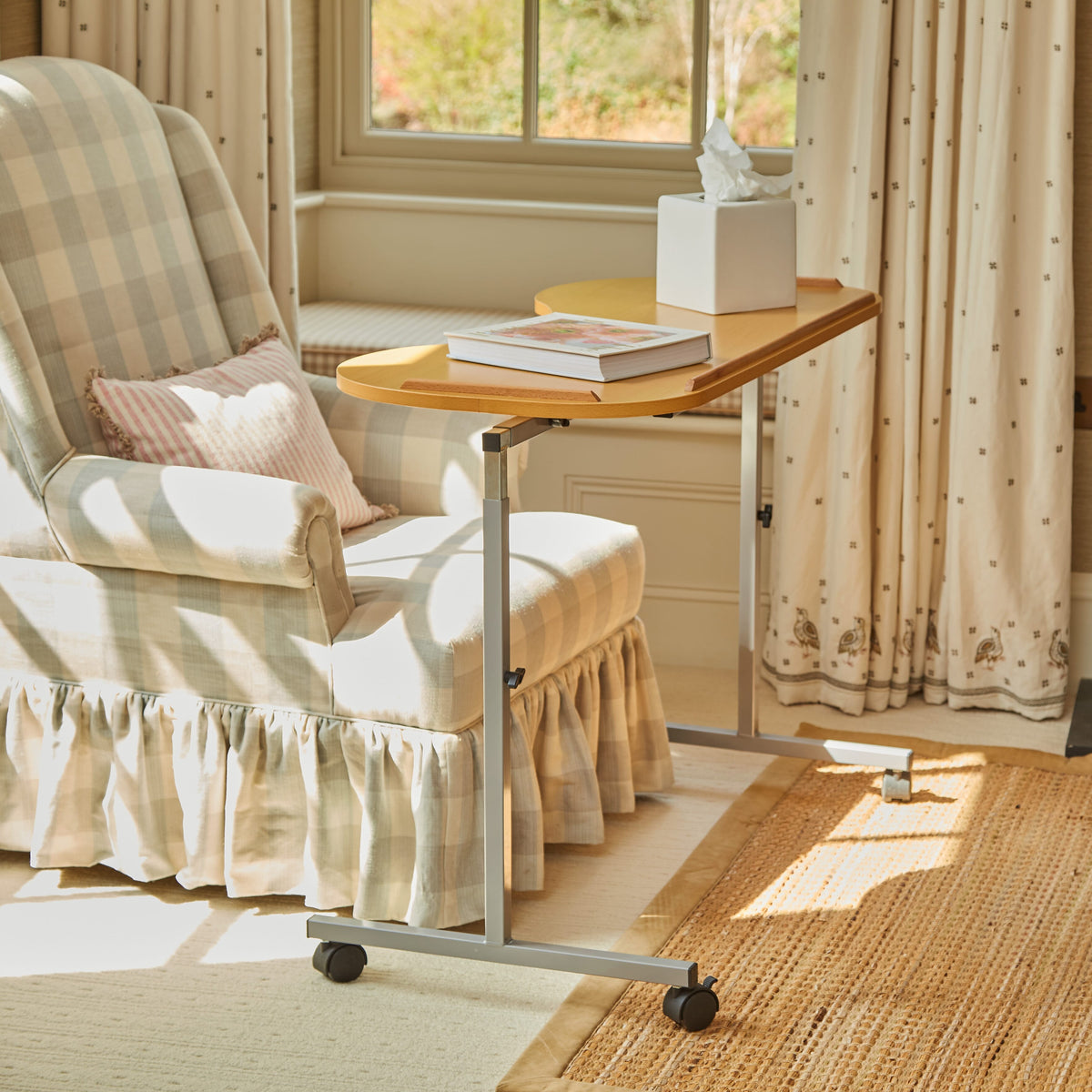 Angled view of NRS Curved Adjustable Overbed Table with beech-effect tilting table top and white U-shaped base on castors against a neutral background.