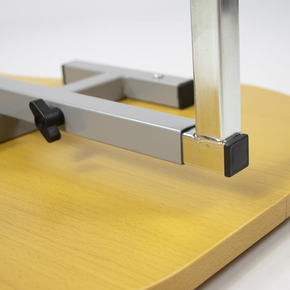 Close-up of the castor wheels on NRS Curved Adjustable Overbed Table, showing the smooth-rolling casters and brake mechanism.