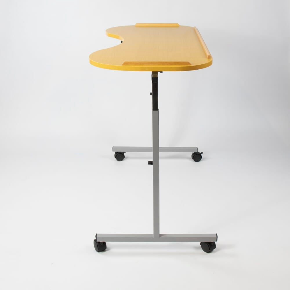NRS Curved Adjustable Overbed Table in use with a magazine or book on the table top, demonstrating its generous surface area.