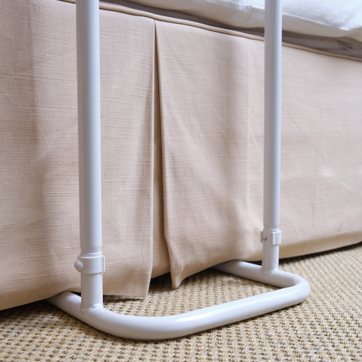 Close-up of a push button or knob on NRS Divan Overbed Table's frame used for adjusting height or tilt.