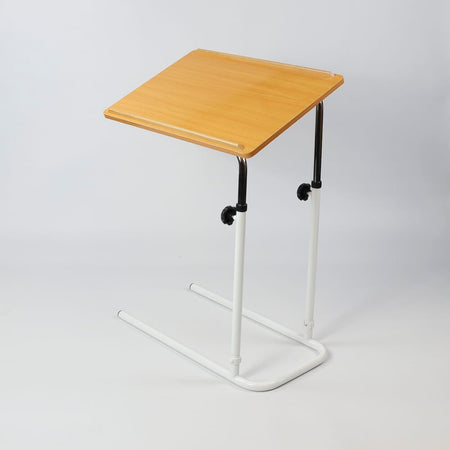 Front view of NRS Divan Overbed Table with the table top tilted, showing the raised lips and attractive beech finish.