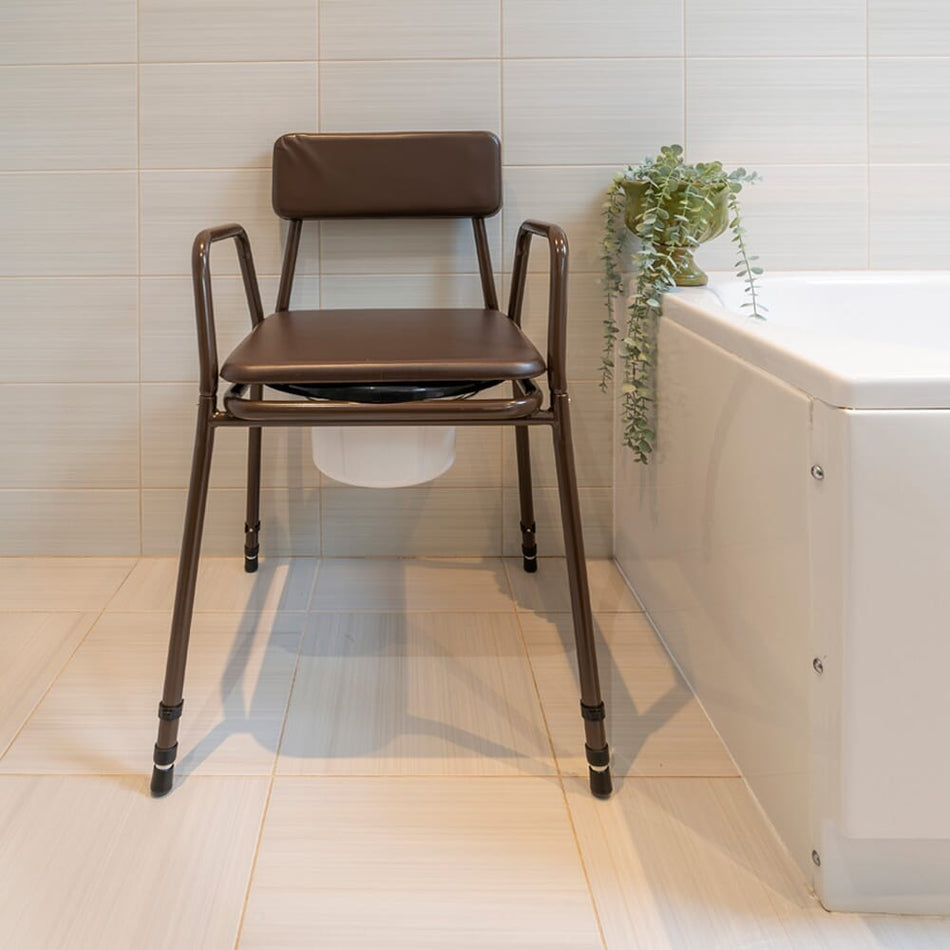 NRS Dovedale Adjustable Commode with Detachable Arms with lid raised showing the open seat and removable commode pan, with supportive arms and adjustable height on a plain background.