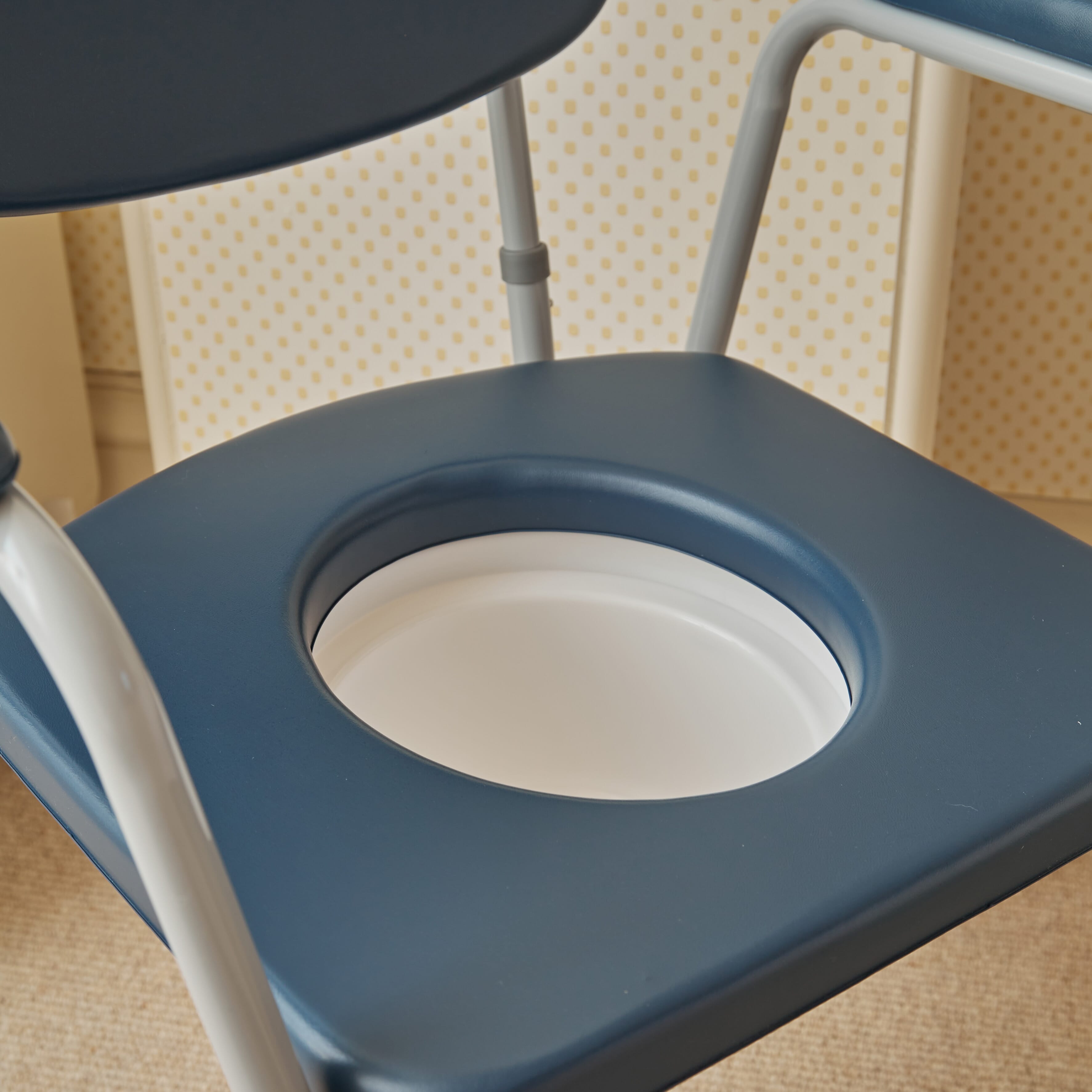 Demonstration of removing the commode pan or adjusting the height on NRS Dovedale Comfort Commode.