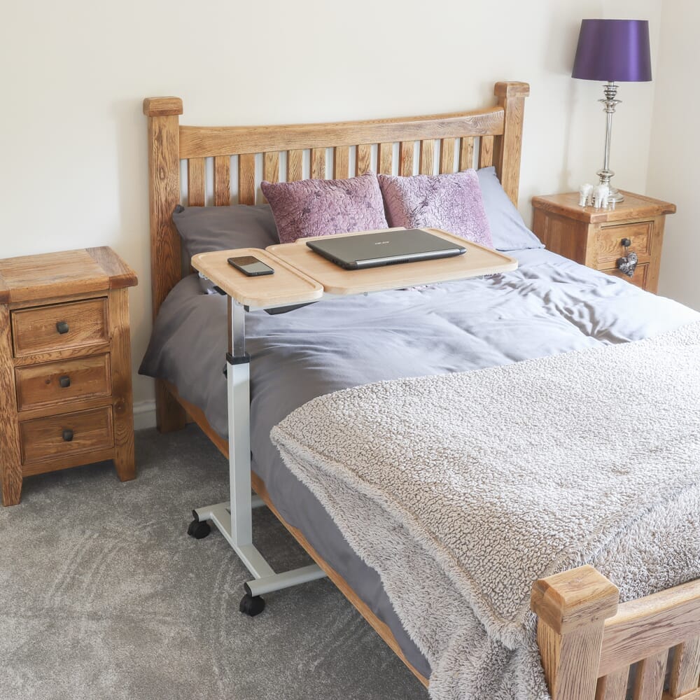 Close-up of the castor wheels on NRS Easylift Home Tilting Overbed Table, showing the smooth-rolling casters and brake mechanism.