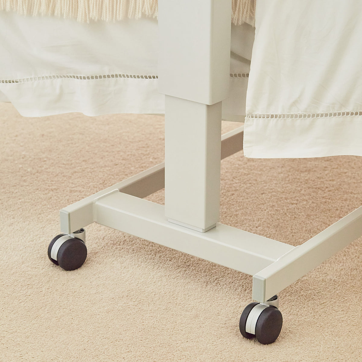 Side view of NRS Easylift Overbed Table-Low showing the tilting top and height-adjustable chrome stems.