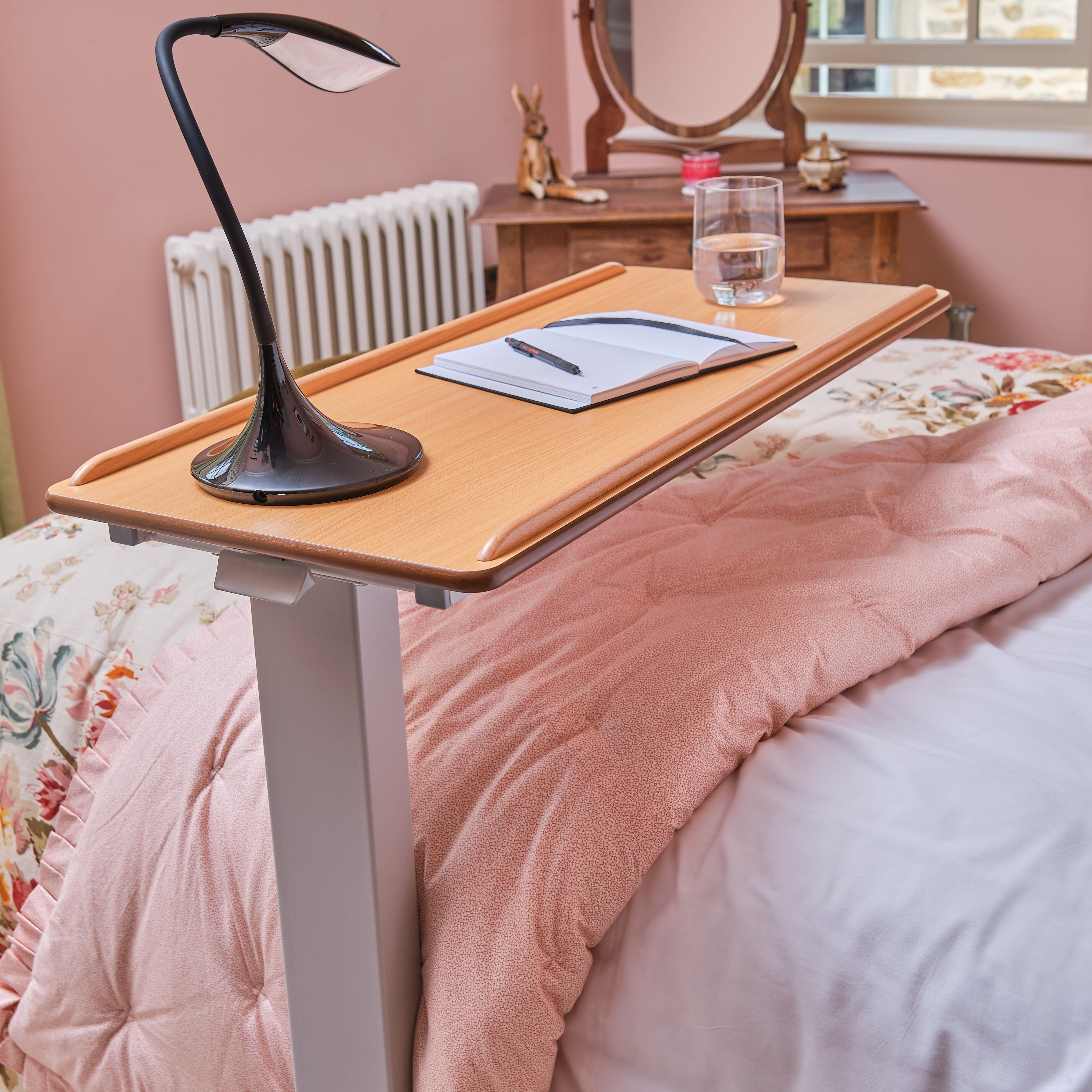 Close-up of the castor wheels on NRS Easylift Overbed Table, showing the smooth-rolling casters and brake mechanism.