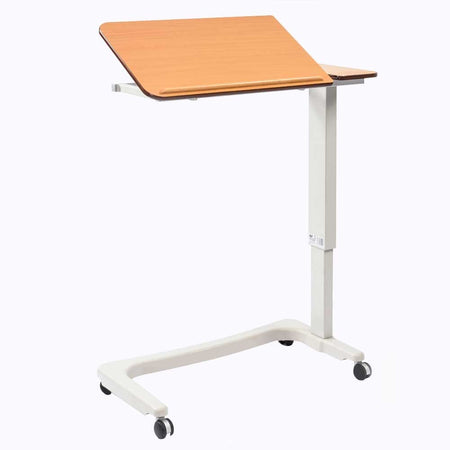 Angled view of NRS Easylift Split Top Overbed Table with beech-effect tilting table top and white U-shaped base on castors against a neutral background.