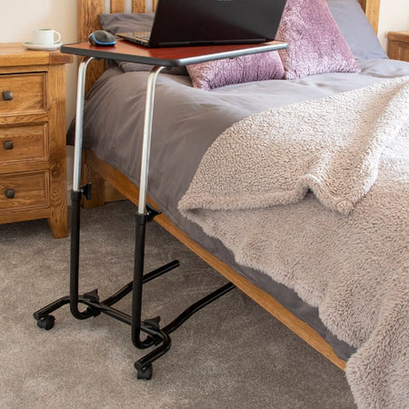 Close-up of hands adjusting the height or tilt of NRS Economy Overbed Table, showing the easy-turn knobs.