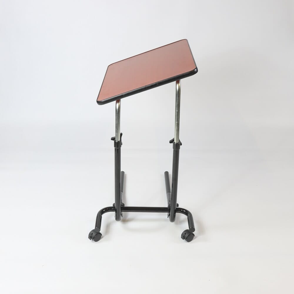 Side view of NRS Economy Overbed Table showing the tilting top and height-adjustable chrome stems.