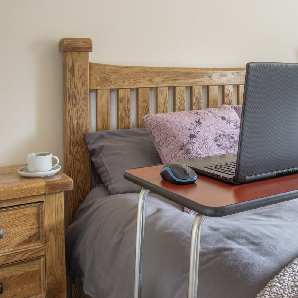 Side view of NRS Economy Overbed Table with the table top level at its lowest height.