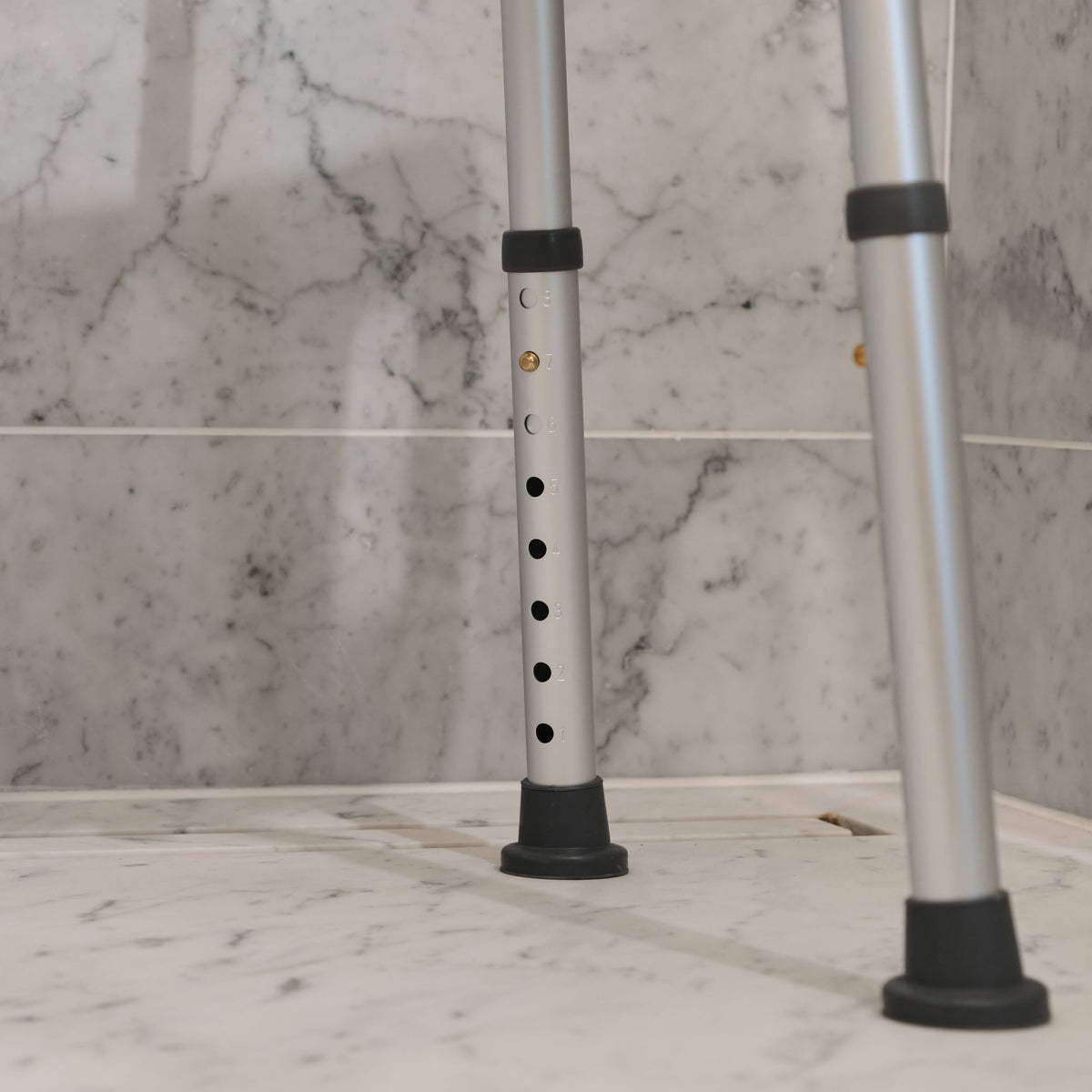 Close-up of the seat on NRS Economy Shower Chair, showing drainage holes and textured surface for comfort.