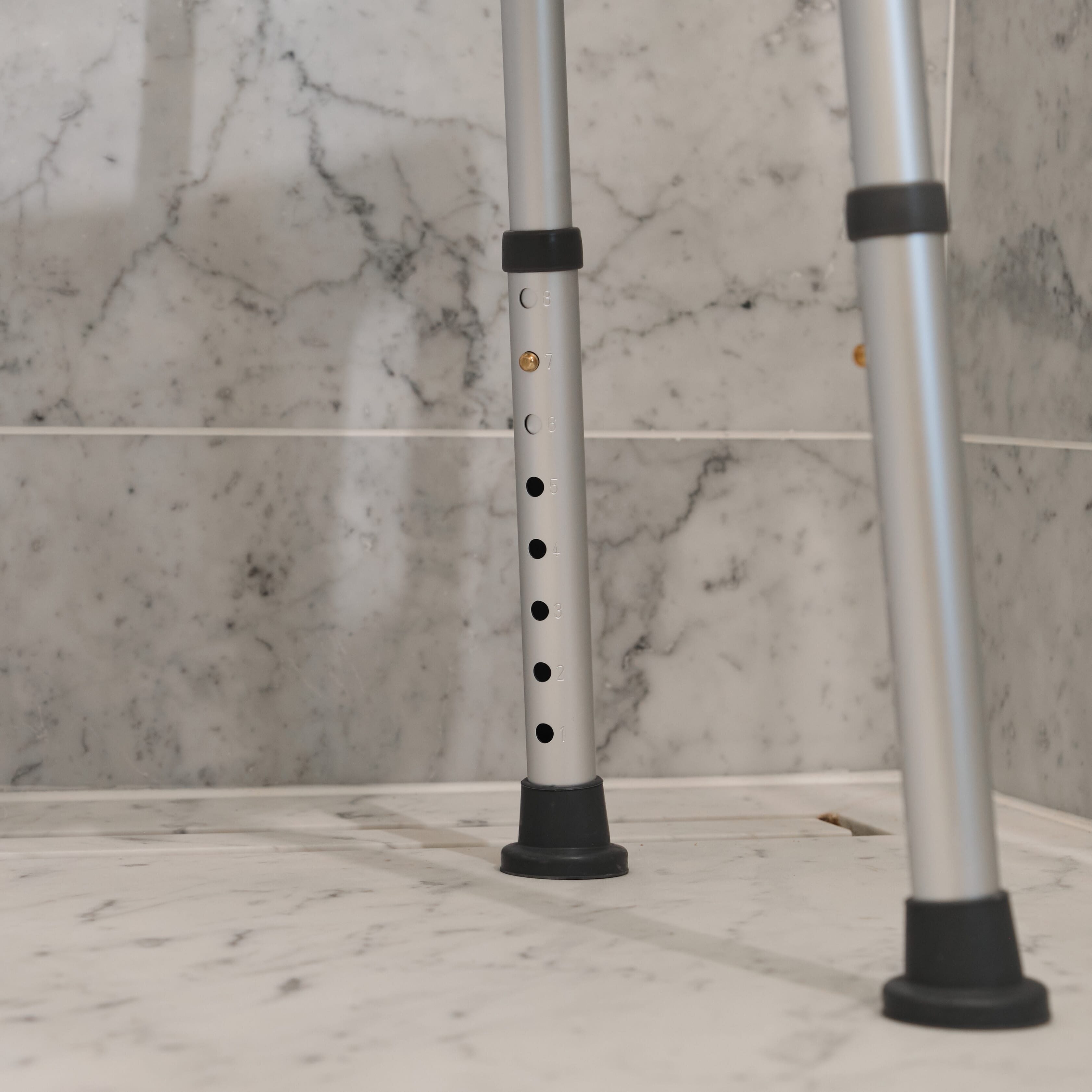 Close-up of the seat on NRS Economy Shower Chair, showing drainage holes and textured surface for comfort.