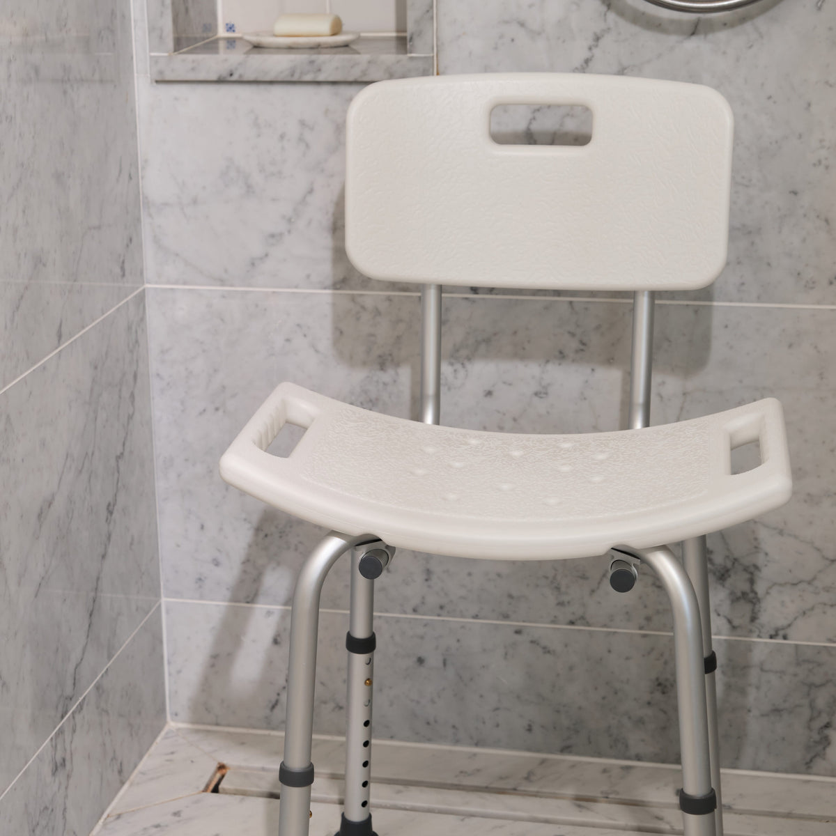 Close-up of a leg on NRS Economy Shower Chair, highlighting the height adjustment mechanism and non-slip rubber ferrule.