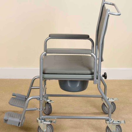 NRS Economy Wheeled Commode positioned in a home environment such as a bedroom or bathroom, demonstrating its discreet appearance.