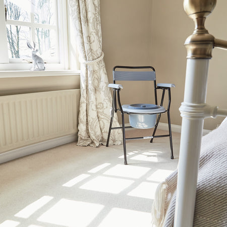 Demonstration of removing the commode pan or adjusting the height on NRS Folding Commode.
