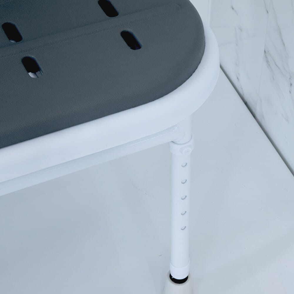 Lifestyle image of NRS Folding Shower Seat with Legs, Padded Seat, Back, and Arms being used in a real-life setting.