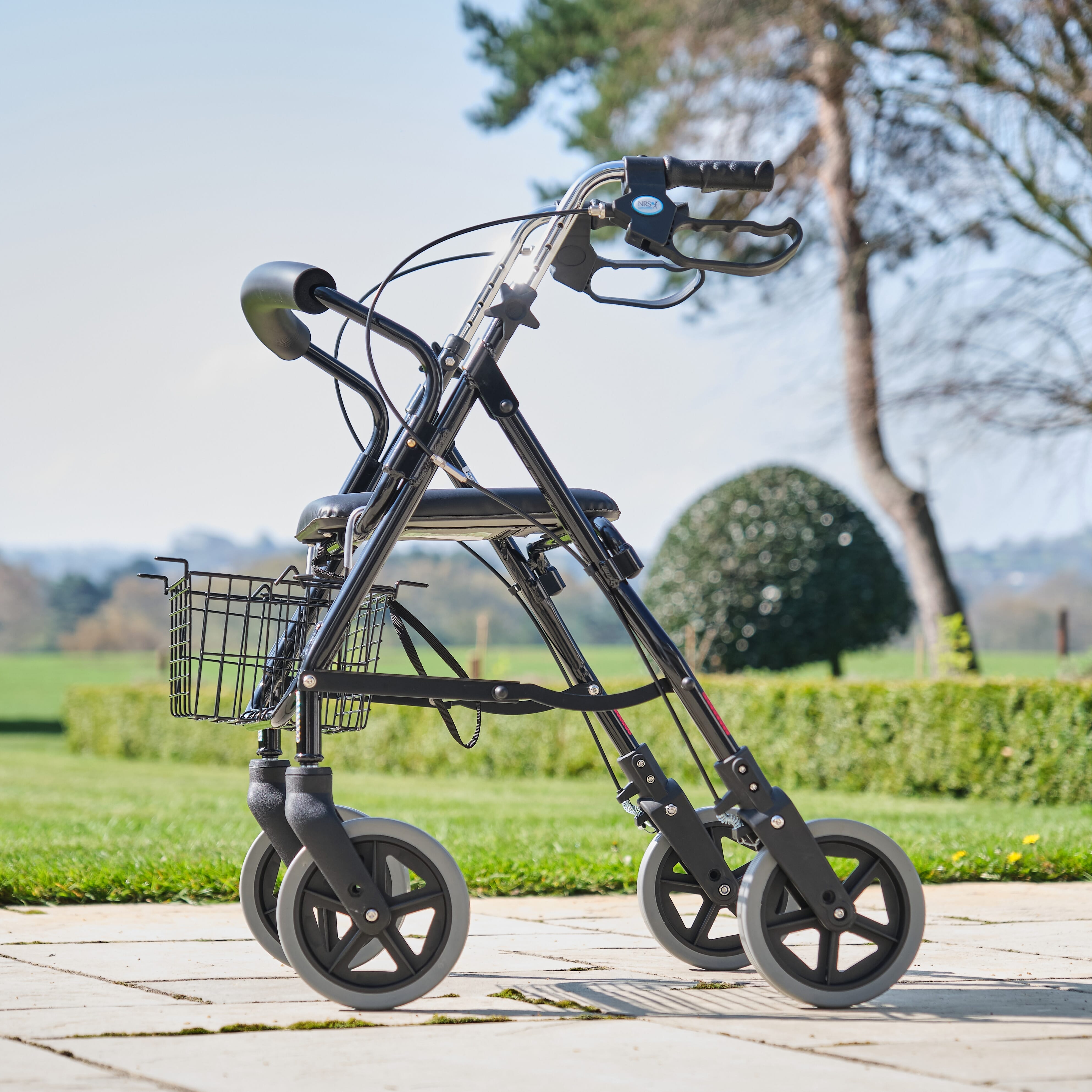 Angled view of NRS Mobility Care Aluminium Rollator rollator with seat, padded backrest, storage bag and four wheels on a plain background.