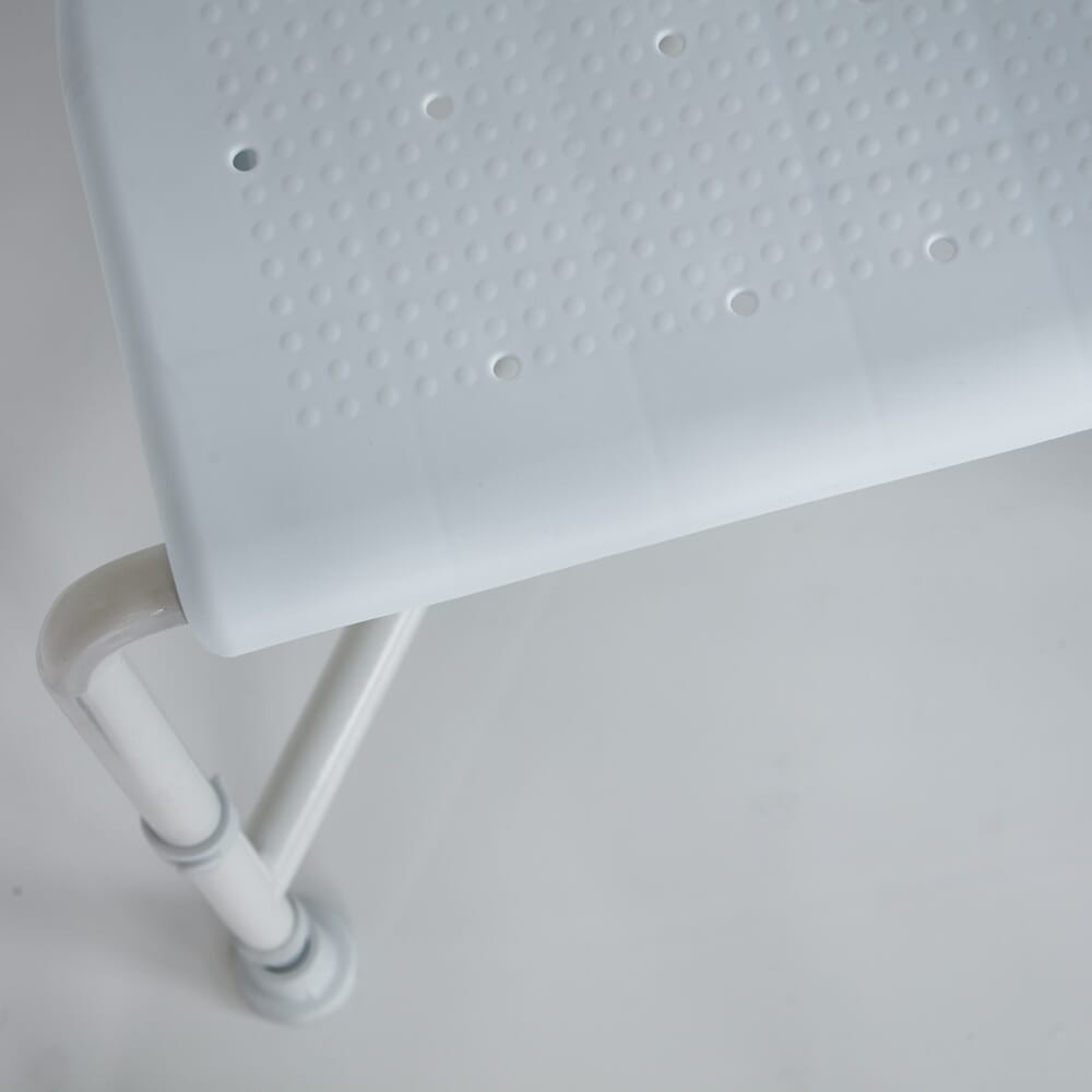 NRS Nuvo Corner Shower Stool placed in a shower to demonstrate safe, space-saving seating.