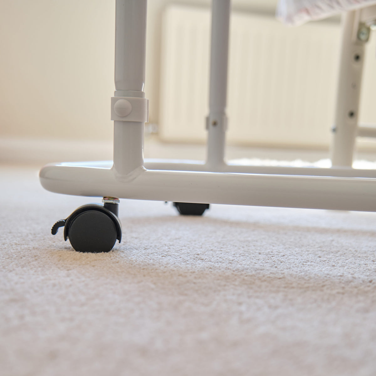 Side view of NRS Overbed Table showing the tilting top and height-adjustable chrome stems.