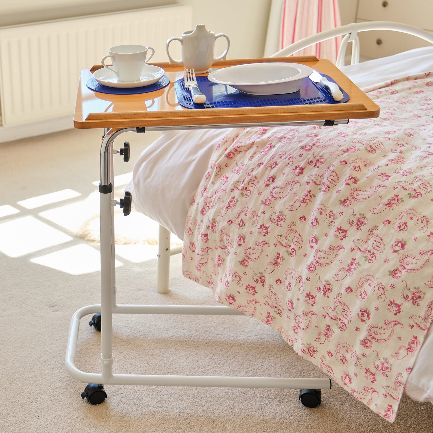 Close-up of a push button or knob on NRS Overbed Table's frame used for adjusting height or tilt.