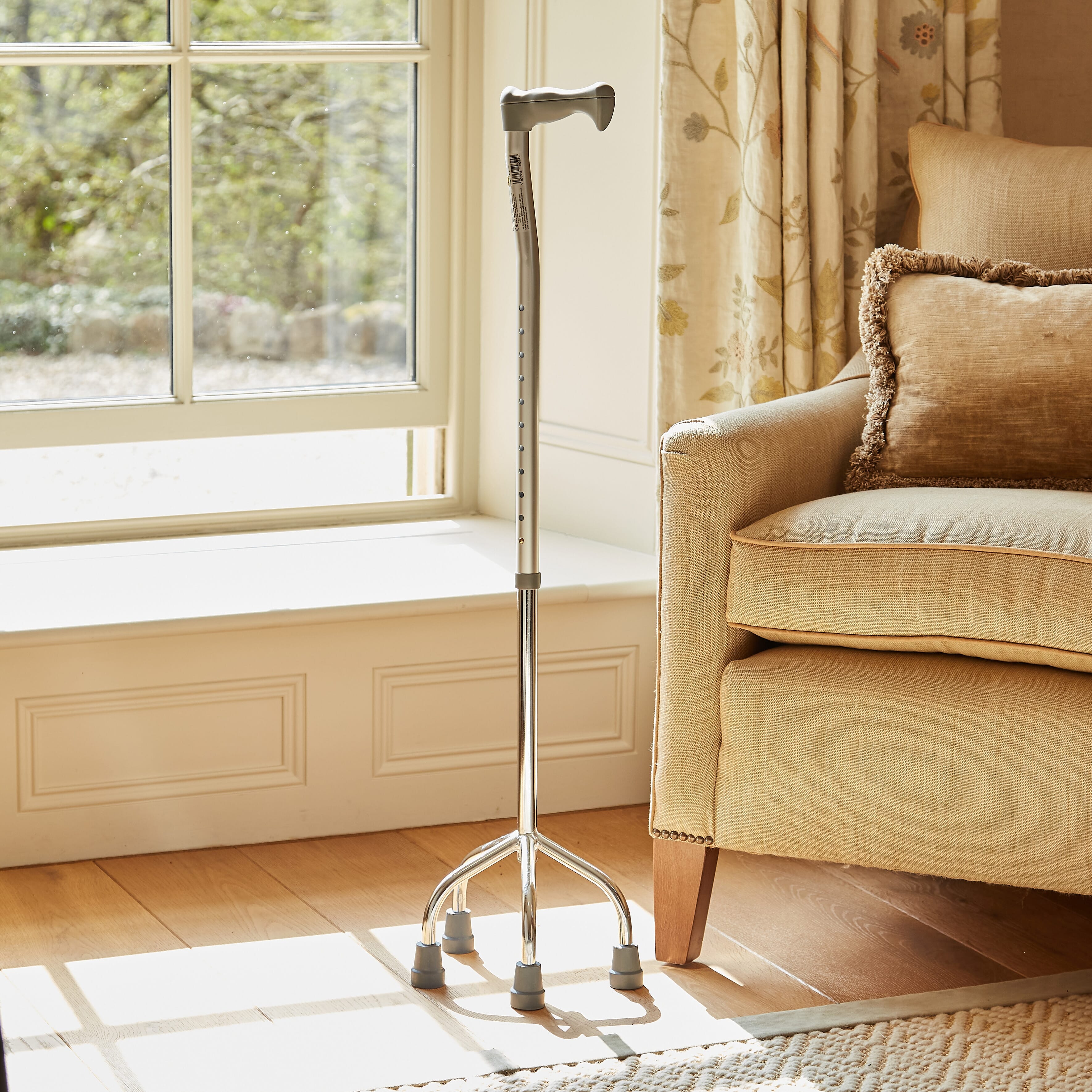 Full view of NRS Quad Base Walking Stick walking stick on a plain background, showing its handle, shaft and ferrule.