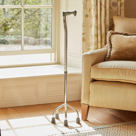 Full view of NRS Quad Base Walking Stick walking stick on a plain background, showing its handle, shaft and ferrule.