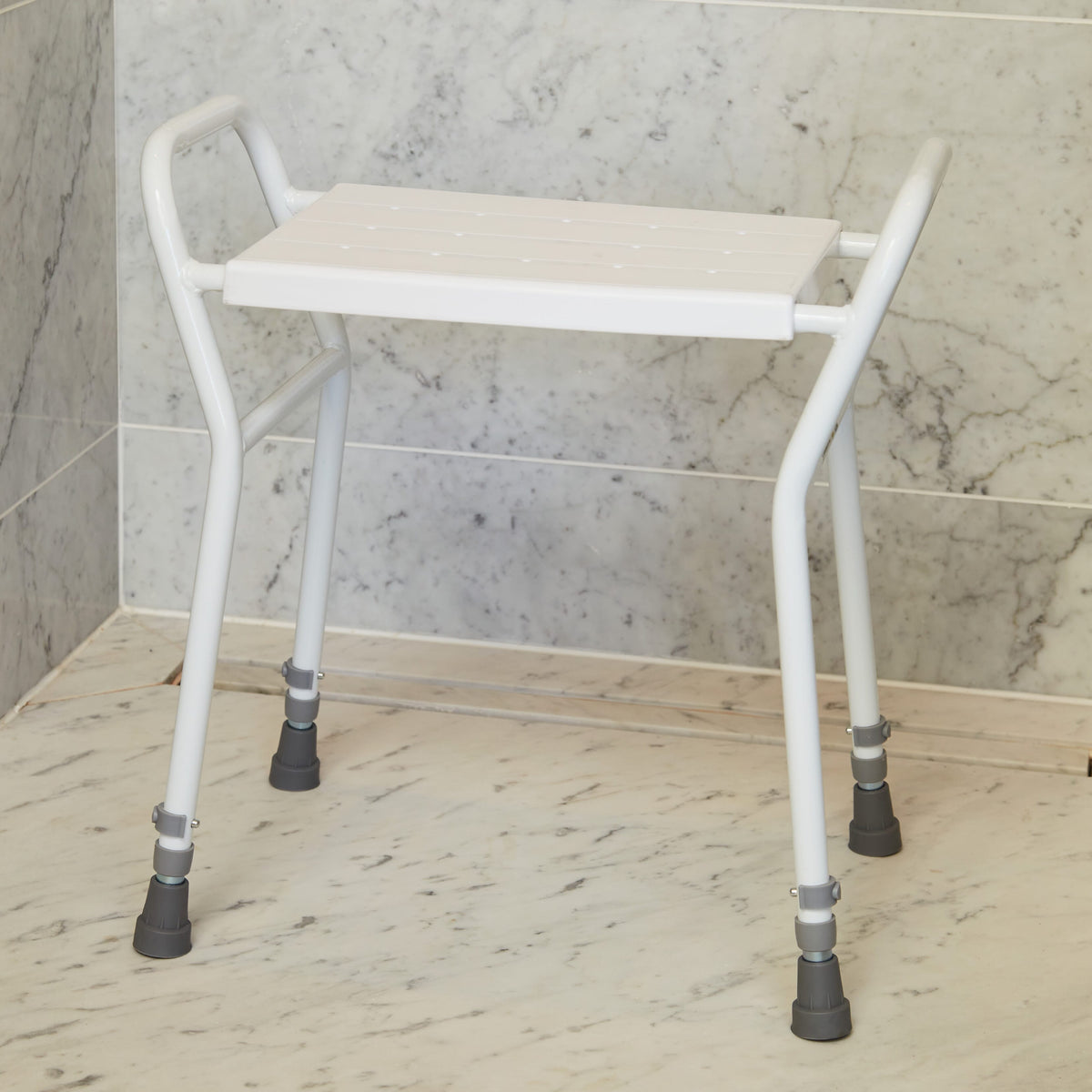 NRS Shower Stool With Handles placed in a shower to demonstrate safe, space-saving seating.