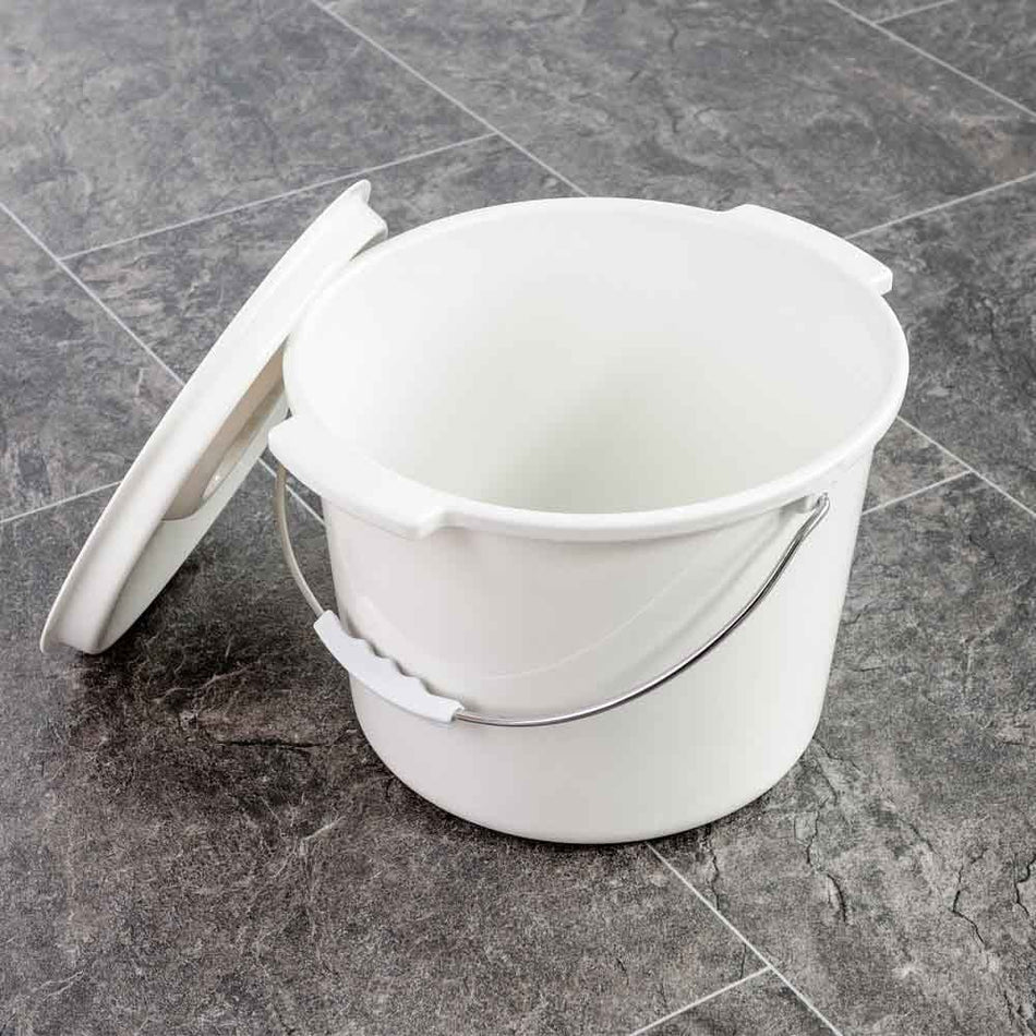 NRS Spare Commode Pan for Height Adjustable Toilet Frame with Seat with lid closed, highlighting the padded seat and discreet design.